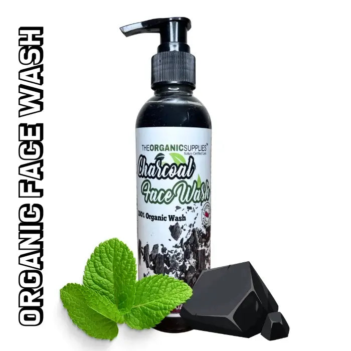 the organic supplies charcoal face wash in pump bottle beside with mint leaves and piece of charcoal 